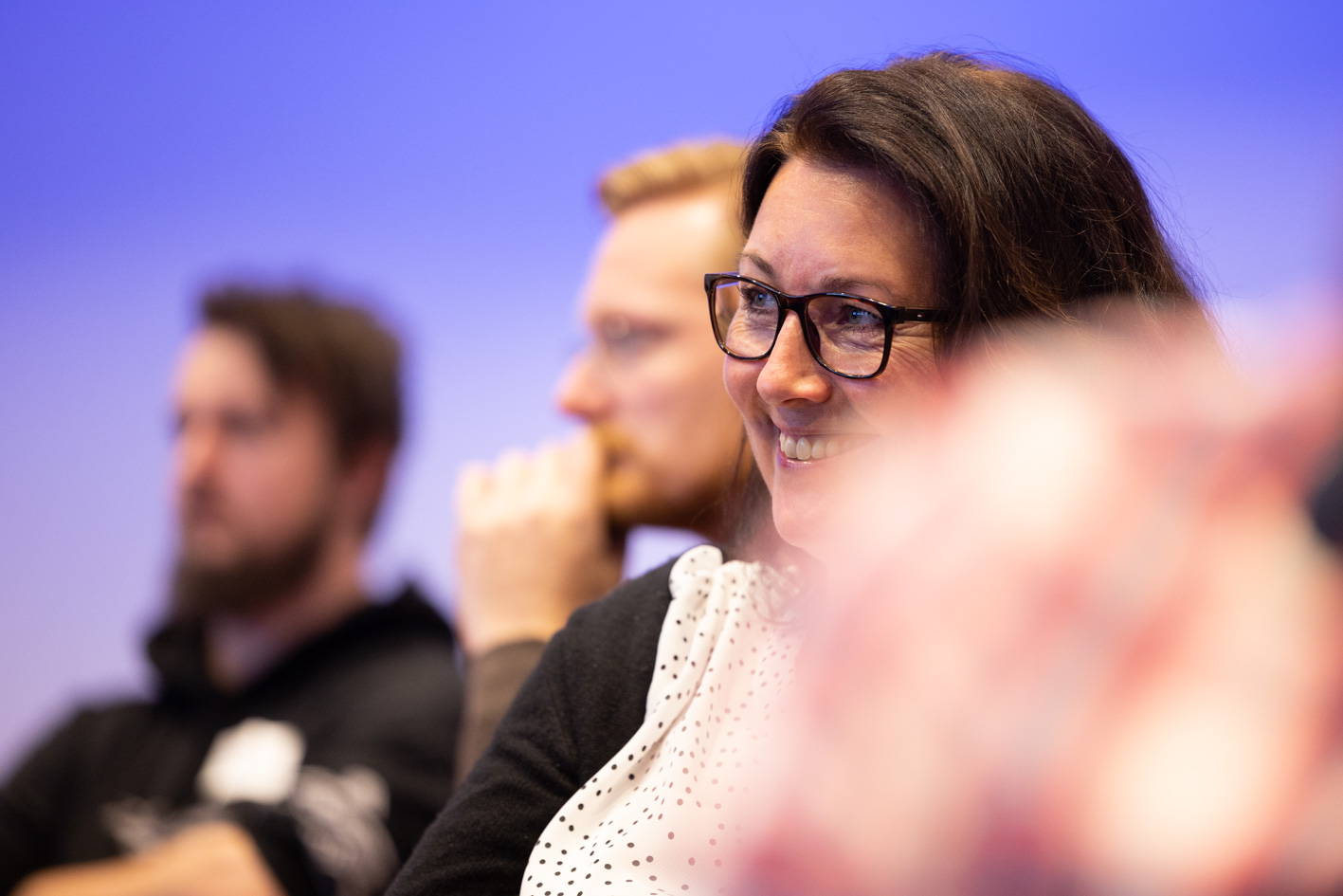 Smilende kollega på Upheads seminar. Foto.